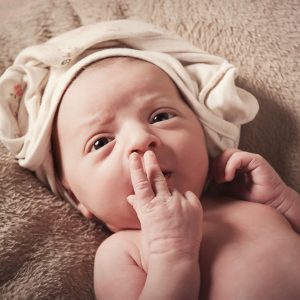 newborn bambina con sguardo dolcissimo e manina sul muso