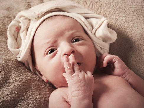 newborn bambina con sguardo dolcissimo e manina sul muso