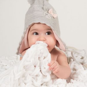 bimba pochi mesi su una nuovola di lana bianca e cappello grigio e rosa