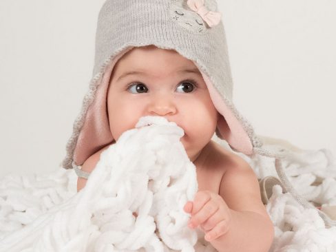 bimba pochi mesi su una nuovola di lana bianca e cappello grigio e rosa