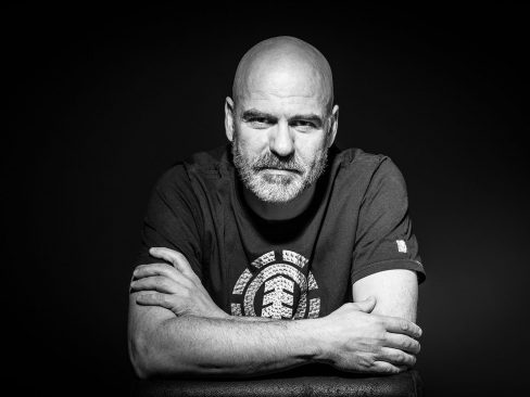 cinquantenne pelato con sguardo accattivante e barba