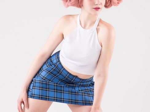 cosplayer con srivali e topo bianchi, minigonna a quadri blu e parrucca rosa